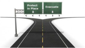 A street sign that says protect in place and evacuate.