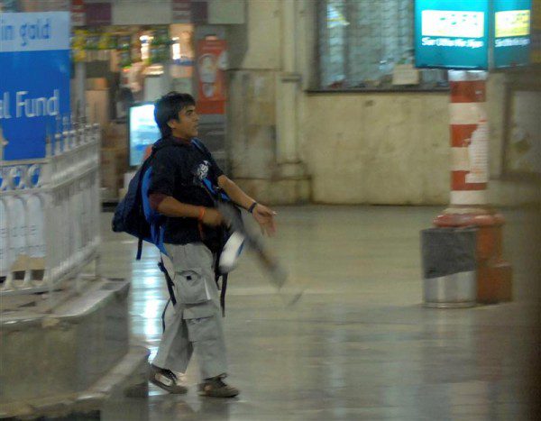 A man walking in the rain with a backpack.