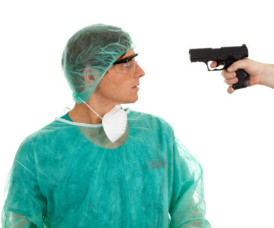 A doctor wearing a full body cover being pointed with a gun